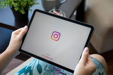 Alanya, Türkiye - 30 Eylül 2021: Kadınlar ekranda sosyal ağ hizmeti Instagram ile iPad Air ile el ele tutuşuyorlar.