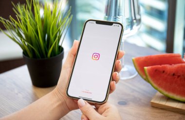 Alanya, Türkiye - 11 Ekim 2021: Kadınlar ekranda sosyal ağ servisi Instagram ile iPhone 12 Pro Max Gold ile el ele tutuşuyorlar