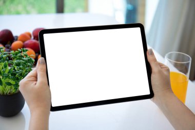 Kafedeki meyvelerin arka planında izole ekranlı bilgisayar tableti tutan kadın elleri 