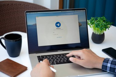 Alanya, Türkiye - 14 Mayıs 2020: Ekranda sosyal ağ servisi Telegram ile masada İnsan Macbook Pro 16 'yı uzattı. Macbook Apple tarafından yaratıldı ve geliştirildi..