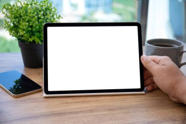 Ofisteki masadaki izole ekranlı bilgisayar tabletini tutan erkek elleri 