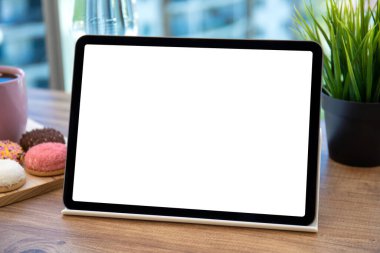 Kafedeki masa arkaplanındaki meyvelerin üzerinde izole ekran bulunan bilgisayar tableti 