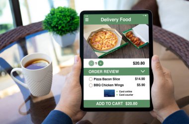 Kafedeki yemek dağıtım uygulamalı bilgisayar tabletini tutan erkek elleri ekranda 