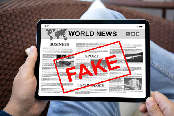 мужчины держат в руках планшет с мировыми новостями и подделкой слов на экране 