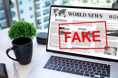 Ofisteki masadaki ekranda haber ve kelime sahte olan dizüstü bilgisayar.