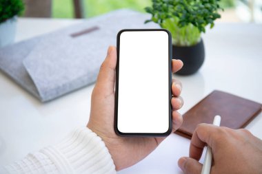 Ofisteki masanın izole ekran arka planına sahip erkek eller telefonu tutuyor. 