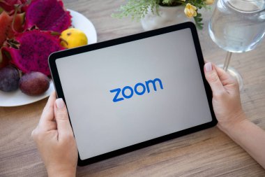 Alanya, Türkiye - 11 Ekim 2021: Kadın elleri Zoom Video İletişim uygulamasını arayarak Apple iPad Air Gray 'i tutuyor.