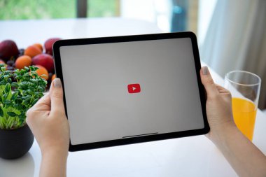 Alanya, Turkey - June 2, 2021: Woman hand holding Apple iPad Air Space Gray with App YouTube provides streaming media and video on the screen.