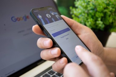 Alanya, Türkiye - 28 Nisan 2022: Sosyal ağ hizmetleri kuryesi Facebook Meta Platformu ile iPhone 13 ile el ele tutuşan adam ekranda ve Google ile Macbook Pro.