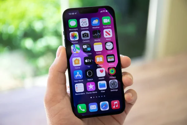 Alanya, Türkiye - 25 Nisan 2022: Ekranda IOS 15 ekranlı iPhone 13 ile el ele tutuşan adam.