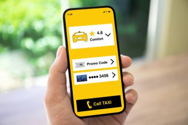 man hand holding phone with application call taxi screen on the street