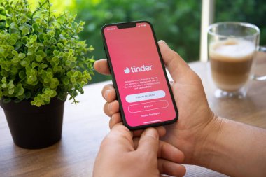 Alanya, Türkiye - 25 Nisan 2022: Çevrimiçi İnternet ağı Tinder ile iPhone 13 'ü tutan adam ekranda.