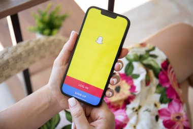 Alanya, Türkiye - 27 Temmuz 2022: Ekranda sosyal ağ servisi Snapchat ile iPhone 13 'ün el ele tutuştuğu kadın. iPhone Apple tarafından oluşturuldu ve geliştirildi..