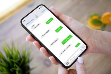 Kafedeki portakallı limonatanın arka planında uygulamalı kuryeyle el ele tutuşan kadın.