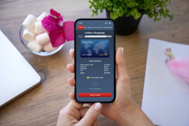 Kafe 'deki bir masanın üstünde internetten alışveriş yapan bir kadın el ele tutuşuyor.