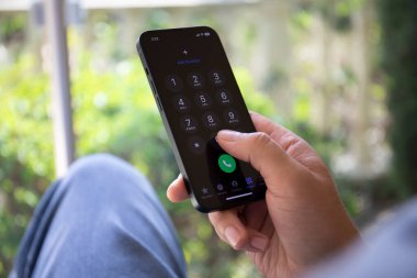 Alanya, Türkiye - 20 Eylül 2022: İnsan eli iPhone 14 grafit ve ekranda çağrı numarası var. iPhone 14 Apple tarafından oluşturuldu ve geliştirildi..