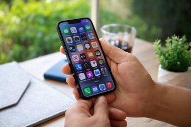 Alanya, Türkiye - 20 Eylül 2022: Ekranda IOS 16 ekranlı iPhone 14 ile el ele tutuşan adam.