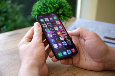 Alanya, Türkiye - 23 Şubat 2022: Ekranda IOS 15 ekranlı iPhone 13 ile el ele tutuşan adam.