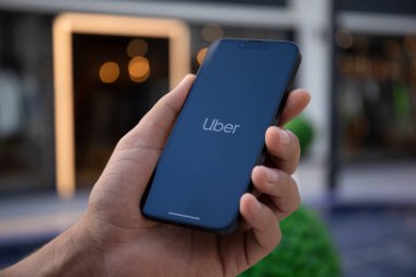 Alanya, Türkiye - 27 Eylül 2022: Ekranda Taksi uygulamalı iPhone 14 ile el ele tutuşan adam.