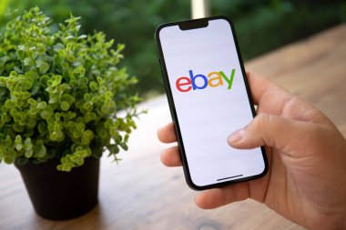 Alanya, Türkiye - 25 Nisan 2022: iPhone 13 Pro Graphite ile çevrimiçi İnternet alışveriş servisi eBay 'i ekranda tutan erkekler.