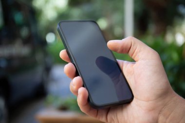 Adam el ele tutuşup yeşil caddenin siyah ekranlı telefon arkaplanını tutuyor