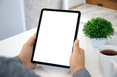 Ofisteki masanın izole ekran arka planına sahip bilgisayar tabletini tutan erkek elleri