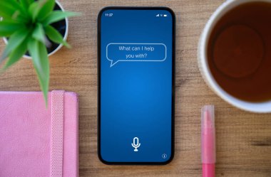 Ofisteki masanın ekranında uygulamalı kişisel asistanı olan telefon