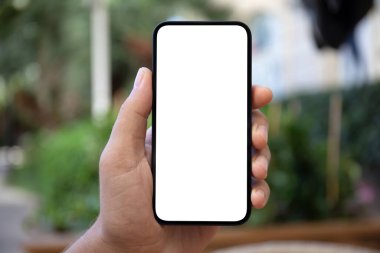 Yeşil caddenin izole ekran arka planına sahip erkek eller telefonu tutuyor