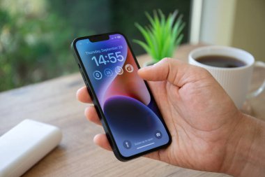 Alanya, Türkiye - 29 Eylül 2022: Ekranda IOS 16 ekranlı iPhone 14 ile el ele tutuşan adam