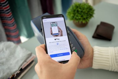 Alanya, Türkiye - 12 Ağustos 2019: Elde tutulan iPhone 8 ve ekranda Apple Pay ve çevrimiçi geçiş terminali. iPhone Apple tarafından oluşturuldu ve geliştirildi..