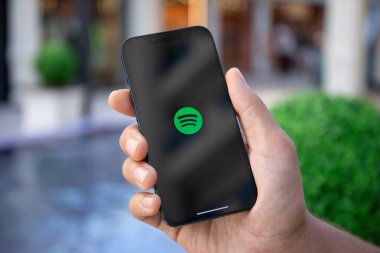 Alanya, Türkiye - 27 Eylül 2022: Apple iPhone 14 'ü bulut ses yayını ve müzik hizmeti Spotify ekranda tutan adam.