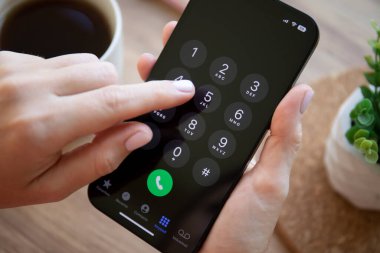 Alanya, Türkiye - 6 Ekim 2022: Ekranda çağrı numarası olan iPhone 14 grafit kadın el ele tutuşması. iPhone 14 Apple tarafından oluşturuldu ve geliştirildi..