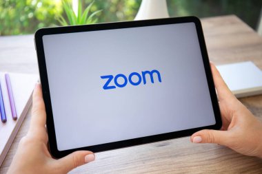 Alanya, Türkiye - 20 Ekim 2022: Kadın elleri Zoom Video İletişim uygulamasını arayarak Apple iPad Air Gray 'i tutuyor.