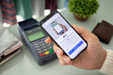 Alanya, Türkiye - 12 Ağustos 2019: Elde tutulan iPhone 8 ve ekranda Apple Pay ve çevrimiçi geçiş terminali. iPhone Apple tarafından oluşturuldu ve geliştirildi..