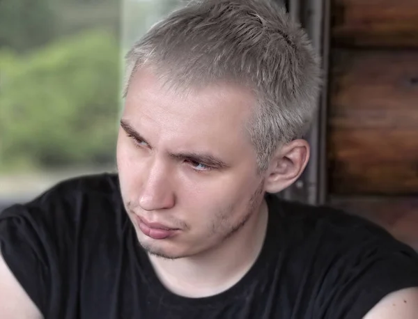 Portrait of a serious guy with gray hair wearing a black T-shirt — Stock Photo, Image