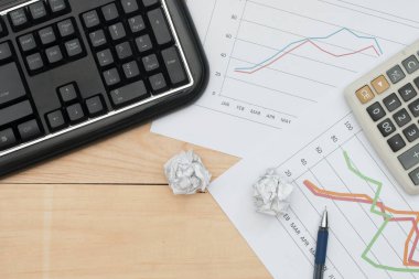 Klavyesi, grafiği, hesap makinesi ve tahta tablosu olan işyeri.