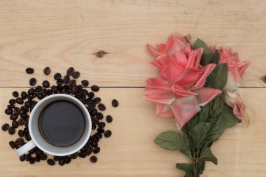 kahve ve çiçekler ahşap masada..