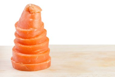 Kesme tahtasındaki havuç dilimi beyaz arkaplanda izole edilmiş.