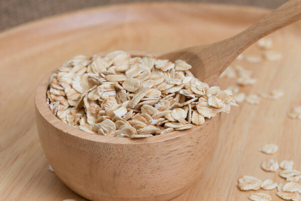 овес в миске на деревянной тарелке.