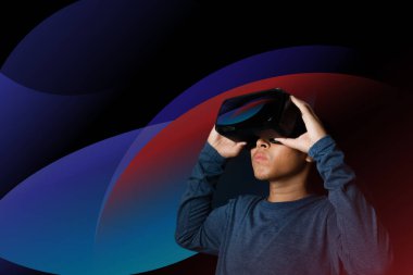 Young man using virtual reality headset. VR, future, technology online concept. Neon light.