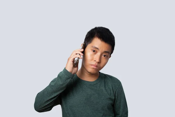 亚洲人在灰色背景下使用智能手机的肖像 — 图库照片