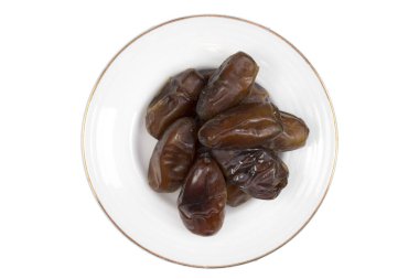 Beyaz arkaplanda izole edilmiş çanakta kurumuş tarihler.