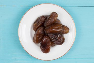 Ahşap masadaki tabakta kurumuş hurmalar..