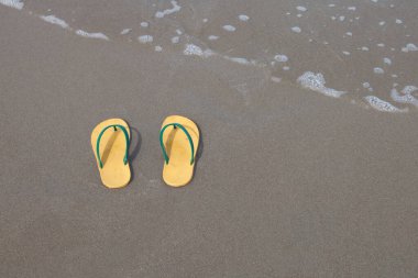 Kumsalda sarı terlik ayakkabı takımı..