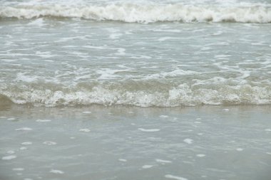 Sahilde deniz dalga yumuşak.