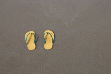 Kumsalda sarı terlik ayakkabı takımı..