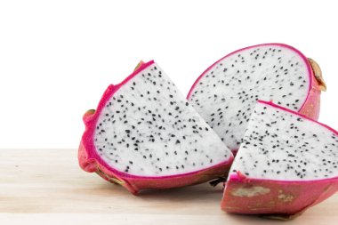 Beyaz arka planda izole edilmiş tahta masada ejderha meyvesi - kırpma yolu.