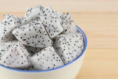 Ejderha meyvesi kasede, tahta masada.