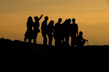 İnsanların silueti kayalıklarda ve dağlarda dinleniyor akşamları günbatımında 
