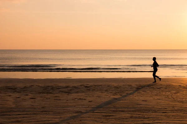 Gün Batımında Sahilde Koşan Bir Kadın Sağlıklı Bir Yaşam Tarzı — Stok fotoğraf